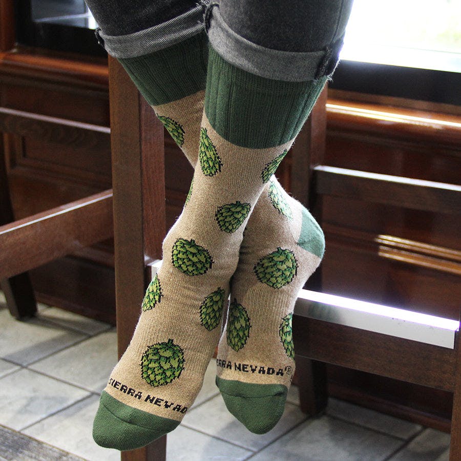 Sierra Nevada Brewing Co. Hop Socks featuring hop pattern worn by a person sitting at a bar