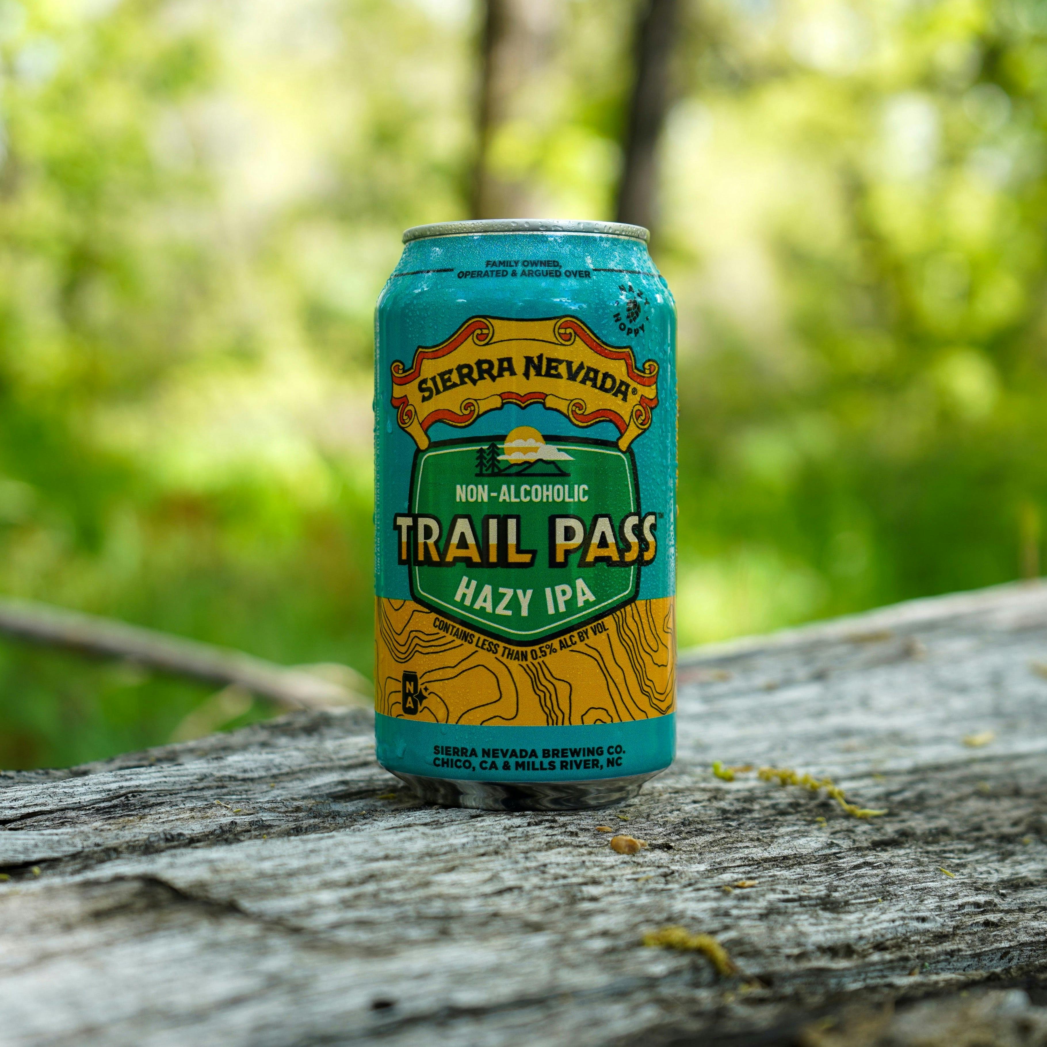 Sierra Nevada Brewing Co. Trail Pass Hazy IPA can sitting on a log in the woods