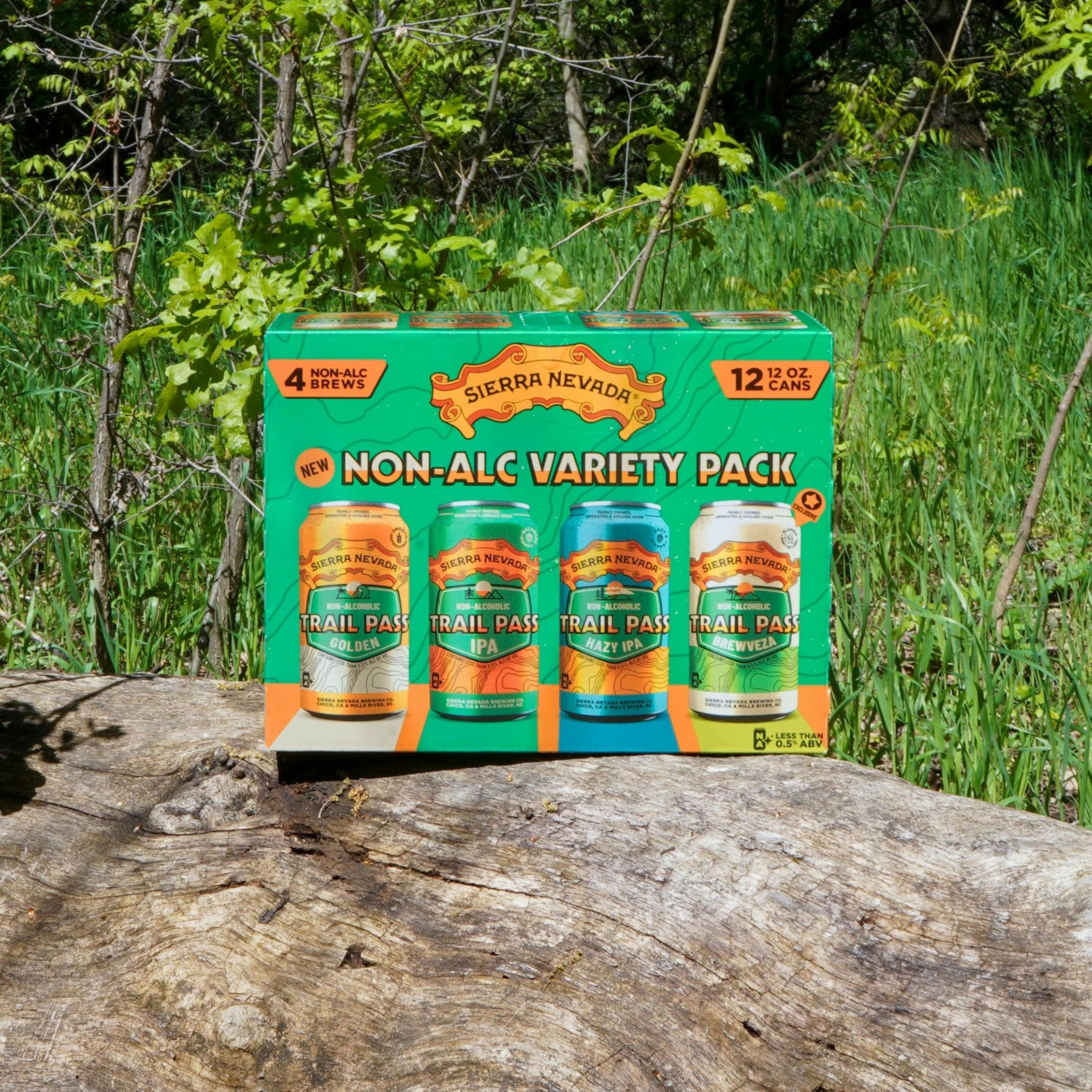 Sierra Nevada Brewing Co. Trail Pass Variety Pack box sitting outside on a log in front of a wooded area